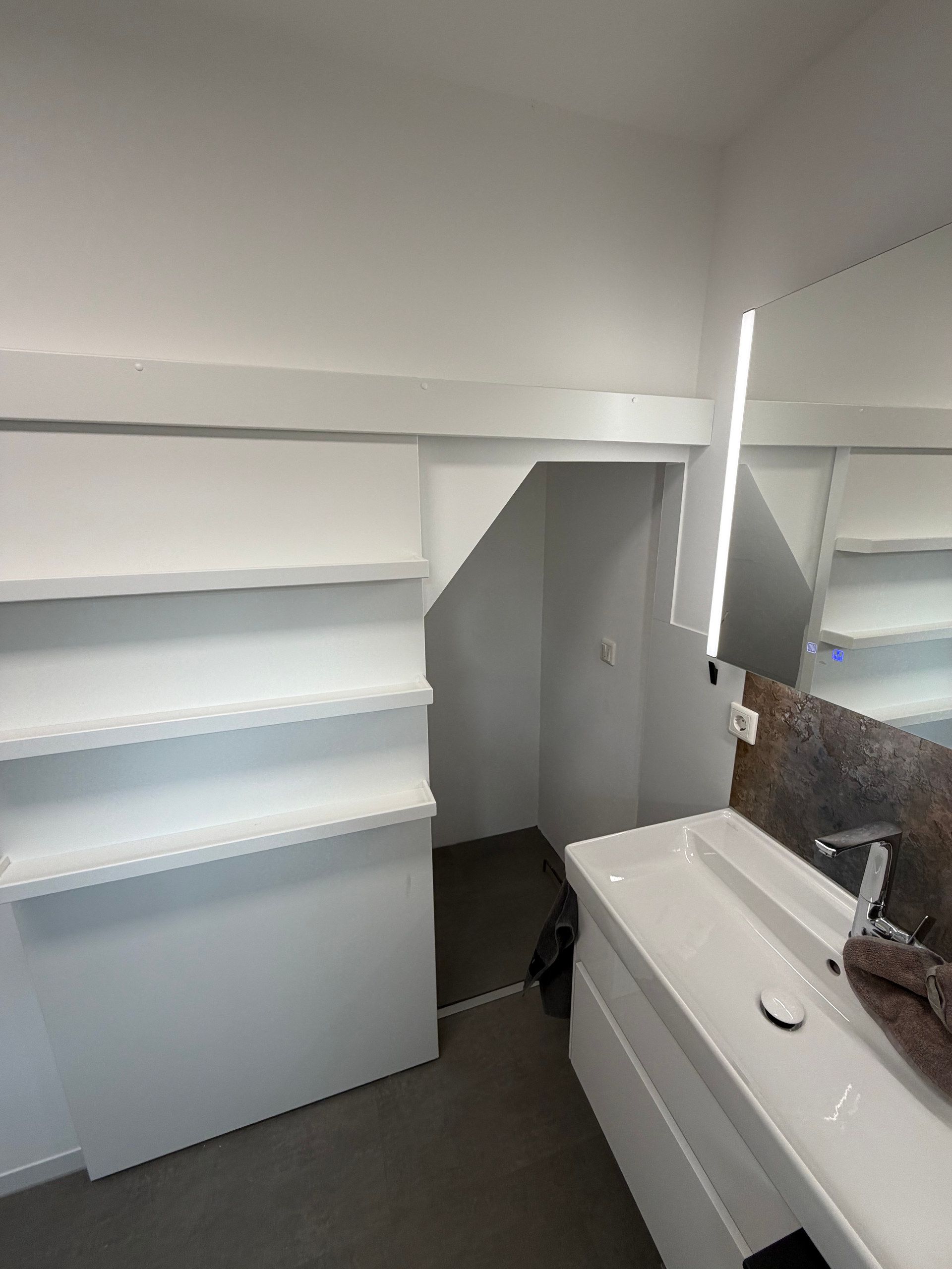 Wandregale neben Waschtisch und Spiegelschrank