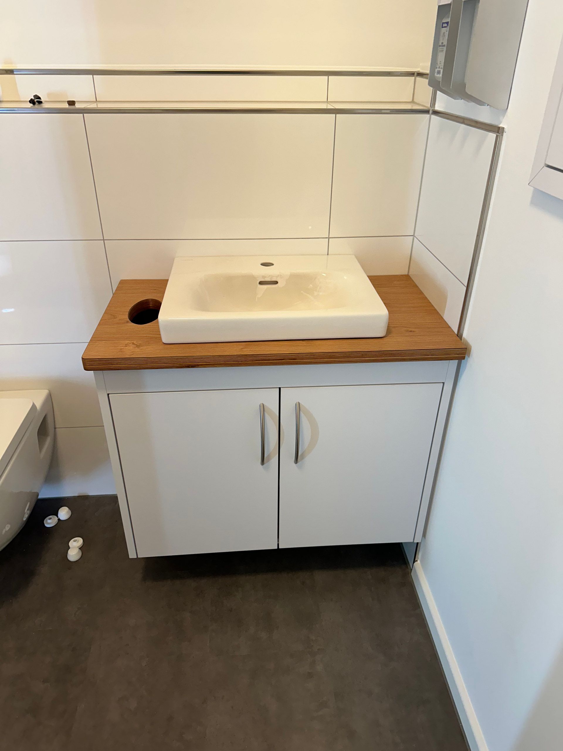 Weißer Waschtisch mit Holzplatte im Gäste-WC