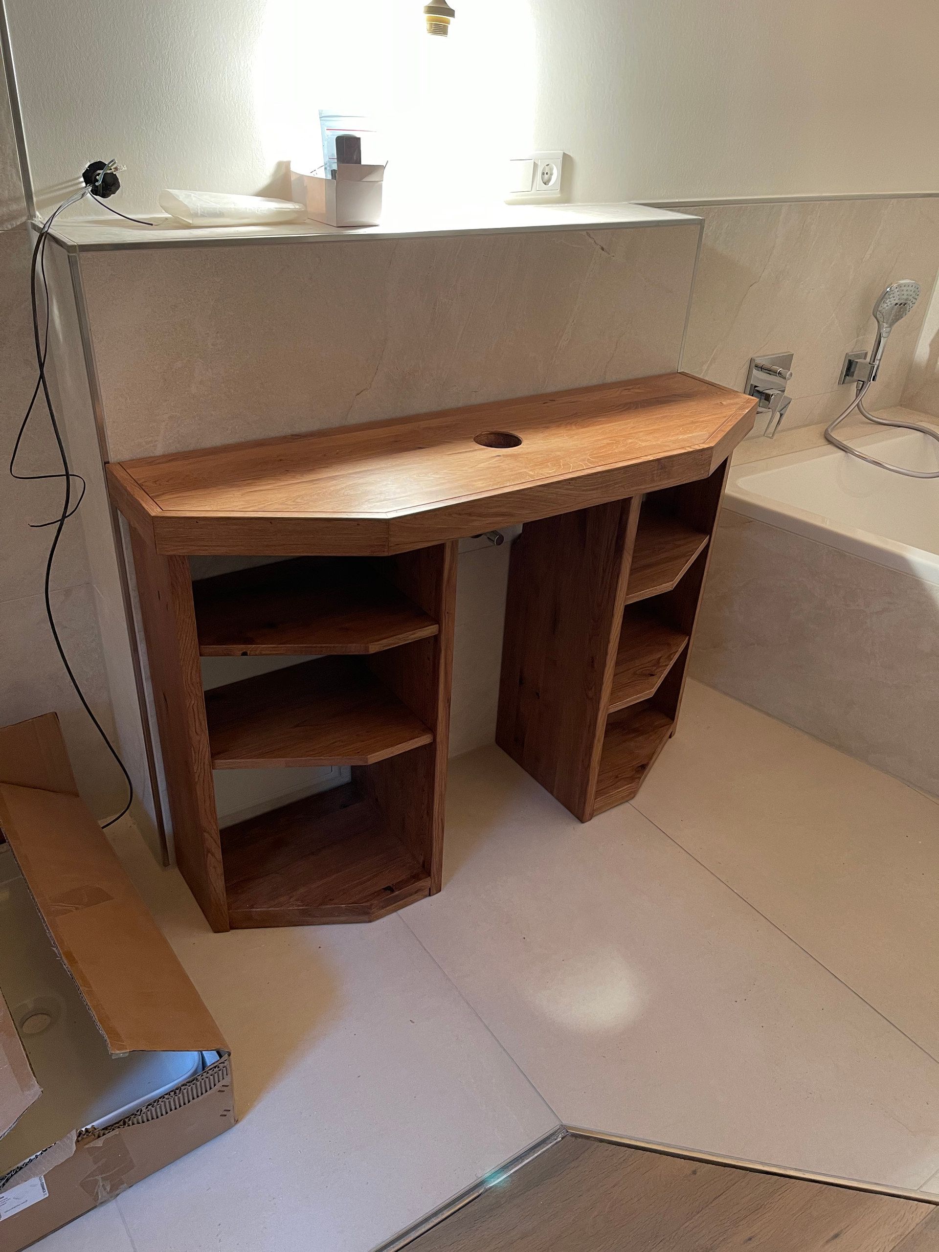 Waschtisch aus Holz mit offenen Fächern vor einer Vorwand