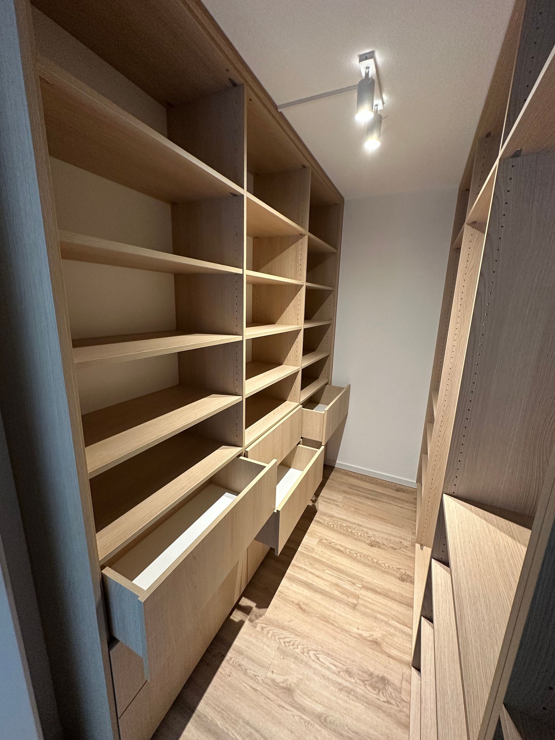 Begehbare Ankleide mit Regalen und Schubladen in Holzoptik