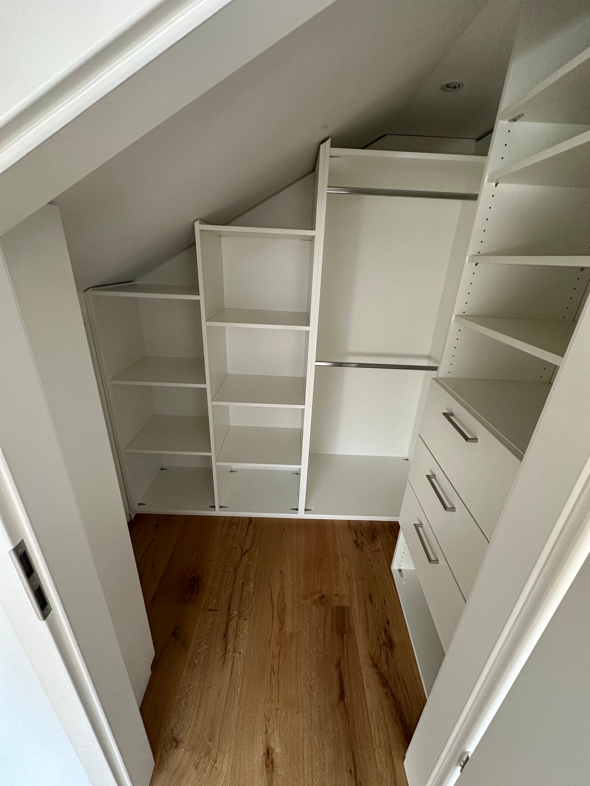 Einbau unter der Dachschräge mit Regalen und Schubladen
