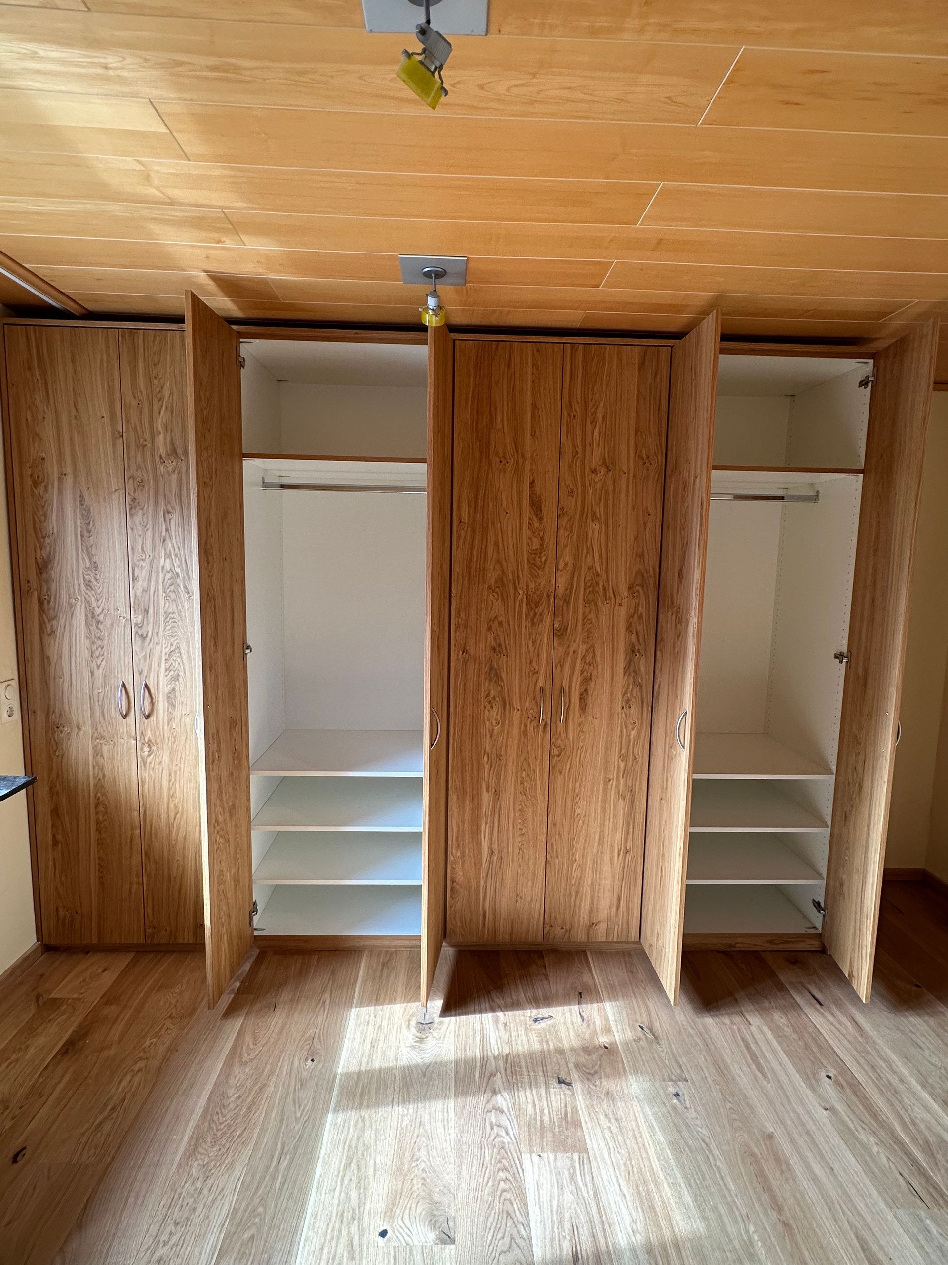 Geöffneter Einbauschrank in Eiche mit Fächern und Kleiderstangen