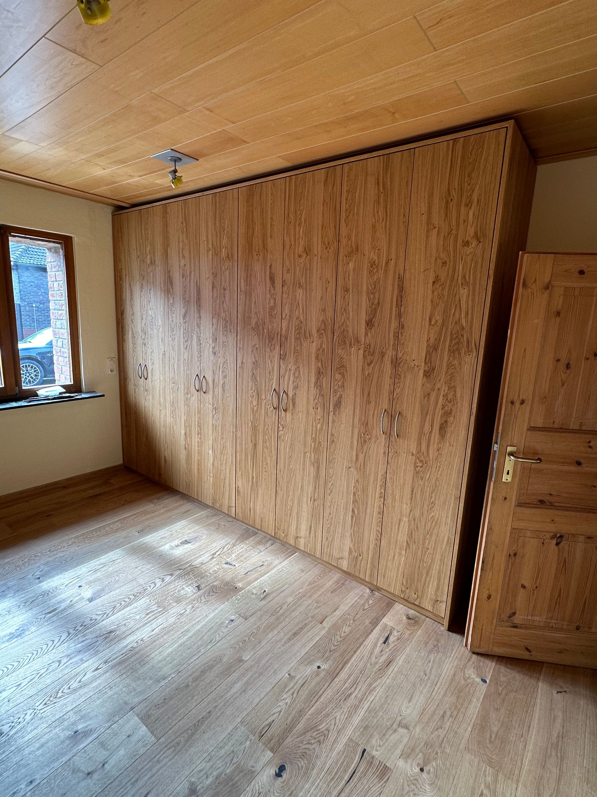 Raumhoher Einbauschrank in Eiche unter einer Holzdecke