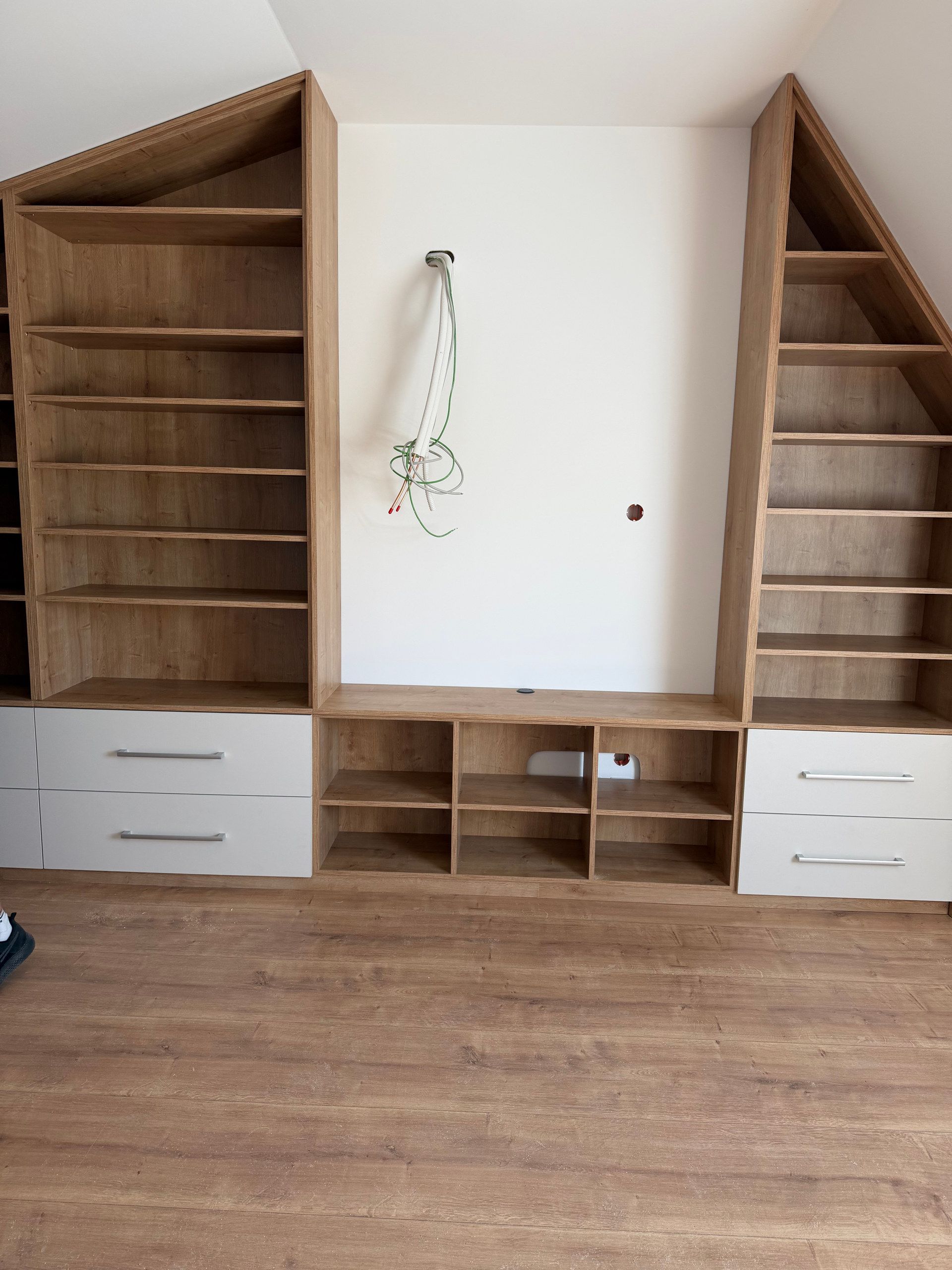 Regalwand in Holz mit Schubladen an der Dachschräge