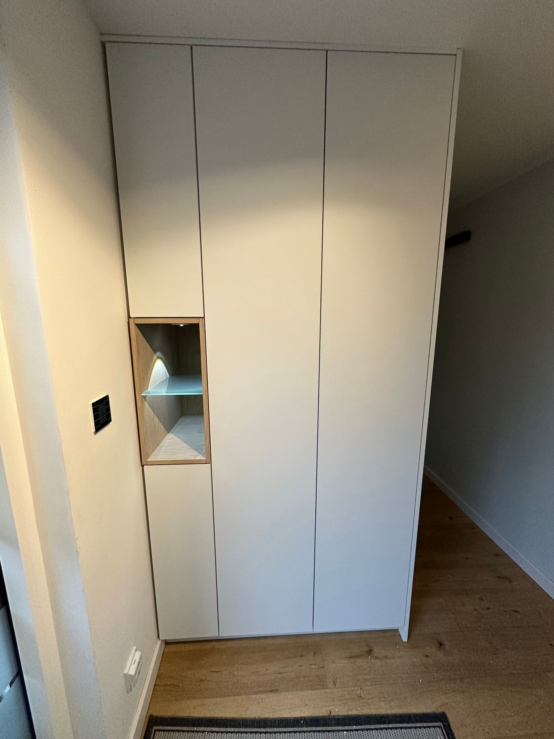 Griffloser weißer Einbauschrank mit beleuchteter Nische