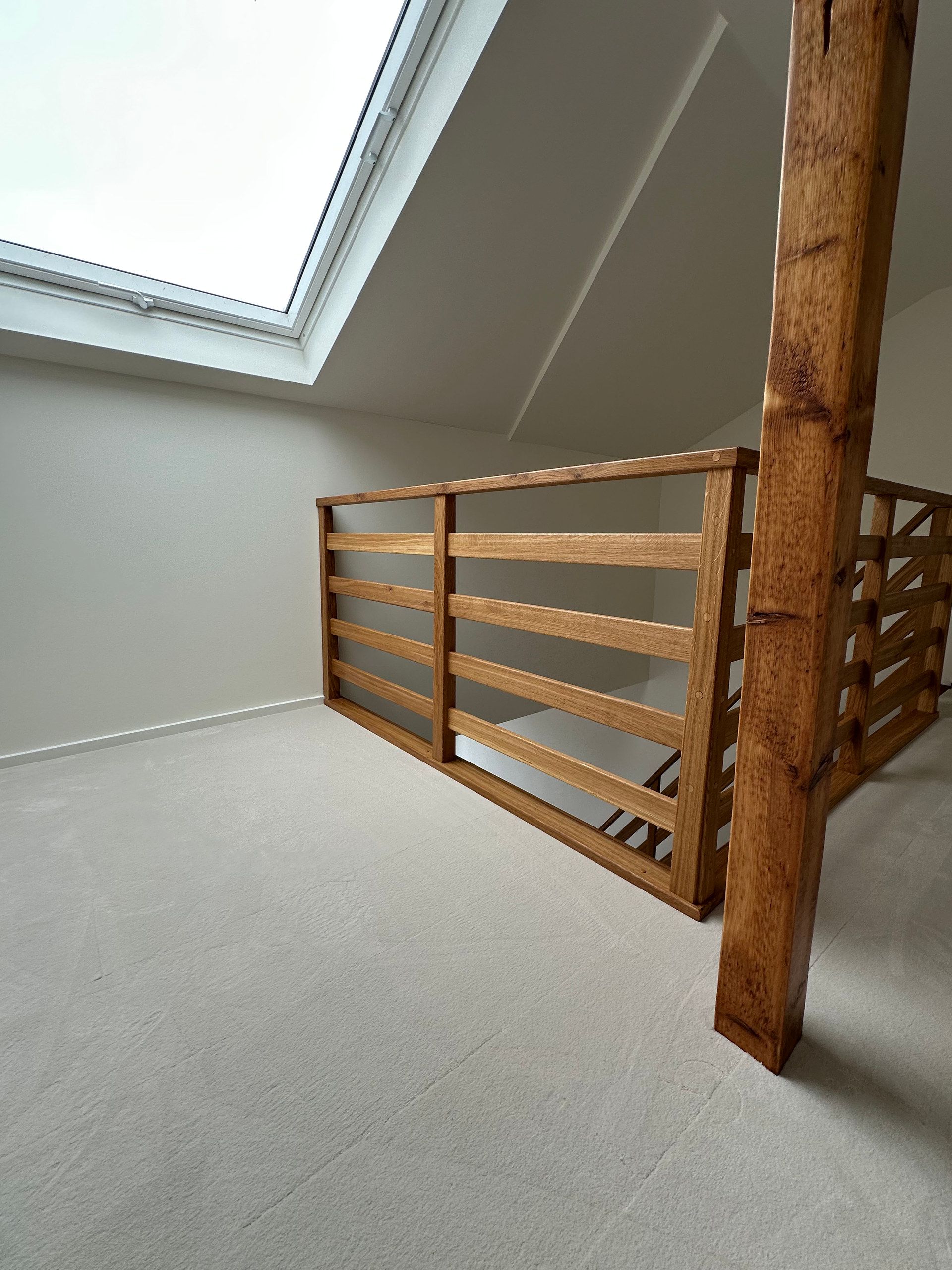 Galeriegeländer aus Holz unter einem Dachfenster