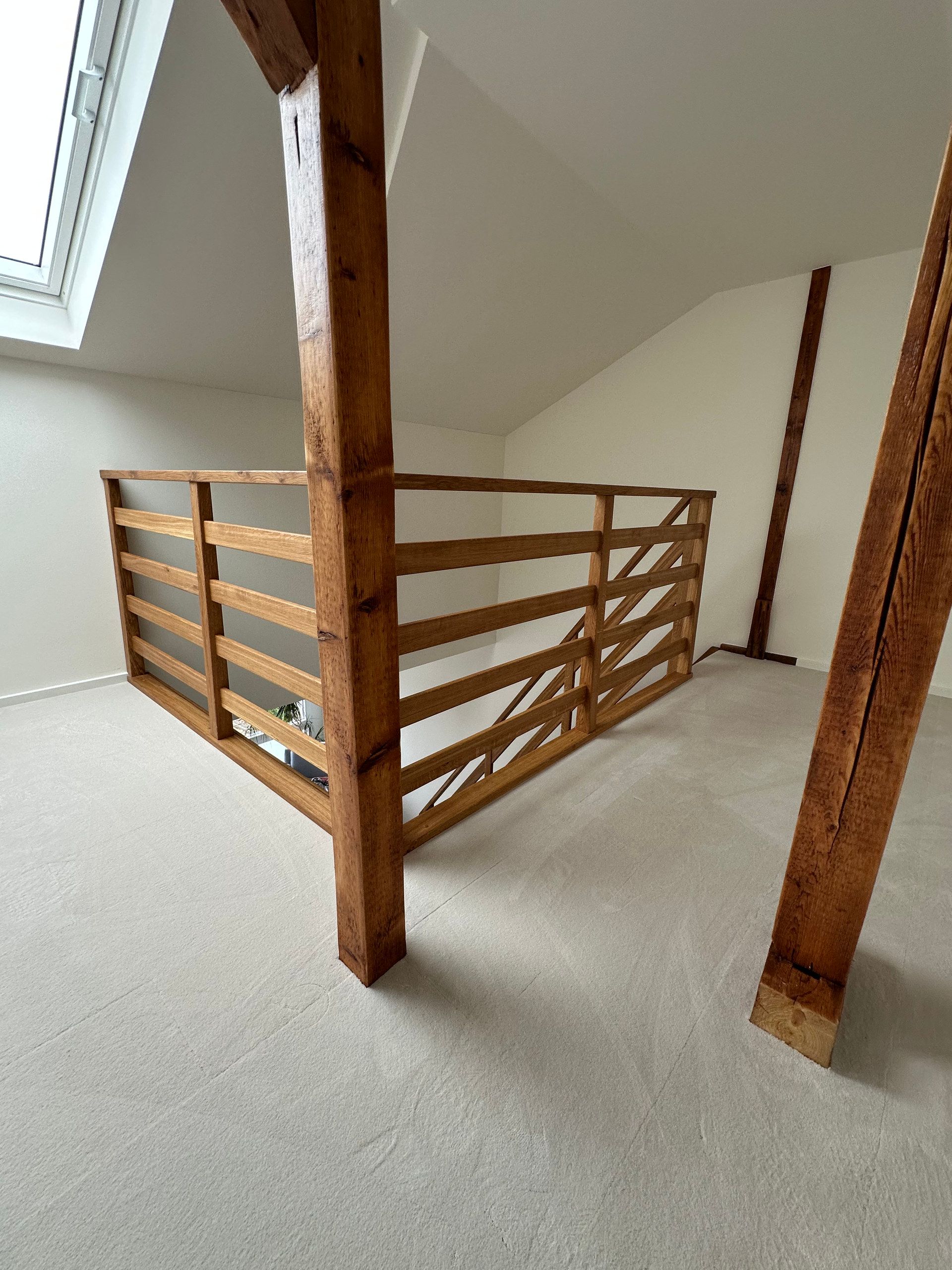 Galeriegeländer aus Holz im Dachgeschoss mit Holzbalken