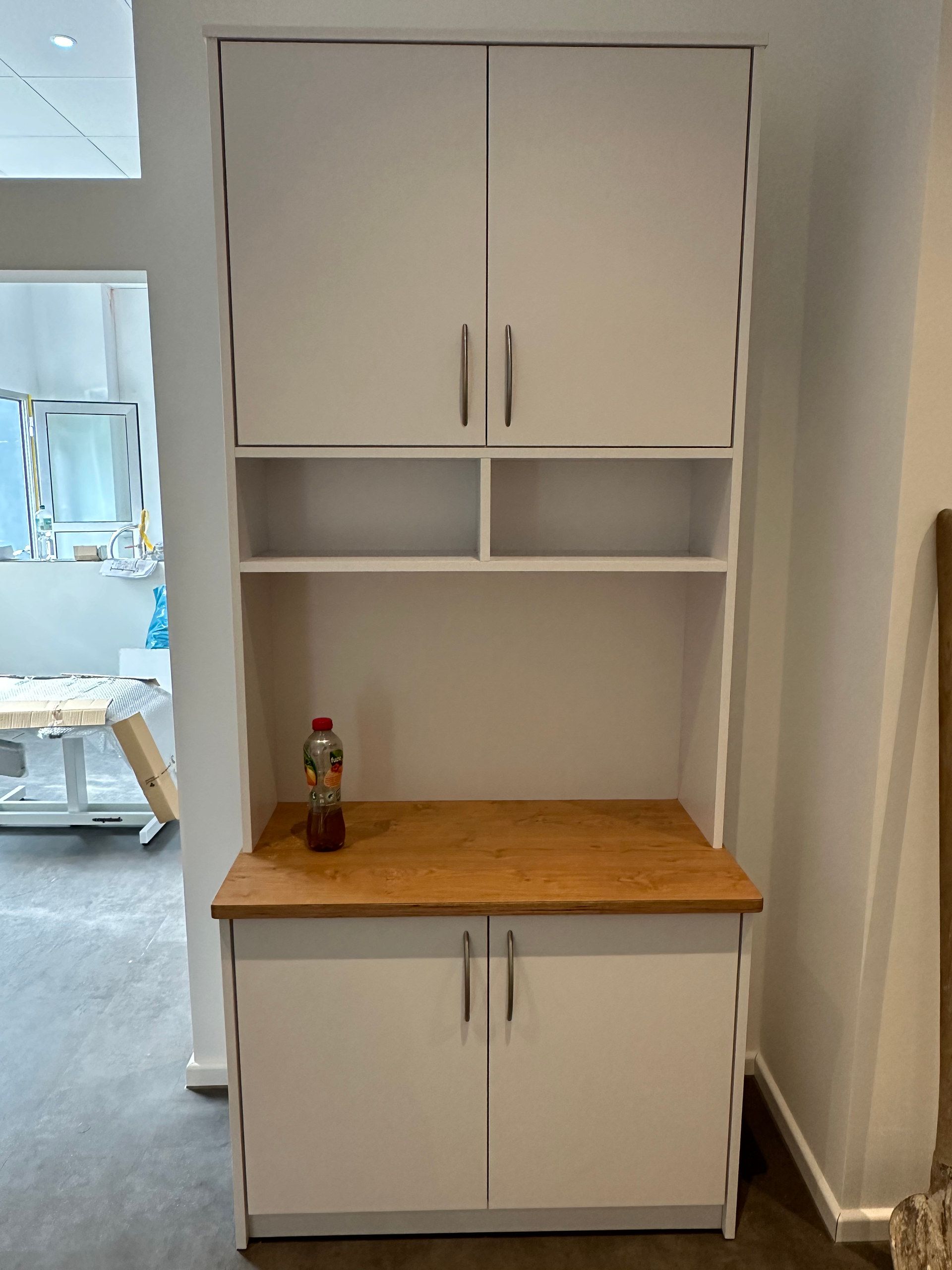 Weißer Hochschrank mit Holzarbeitsfläche in einer Büro-Teeküche