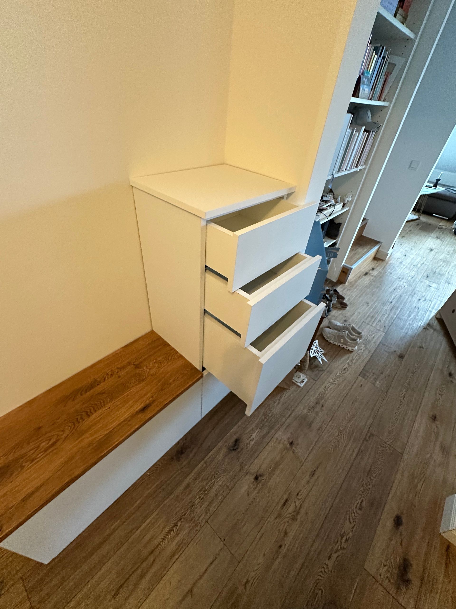 Sitzbank aus Holz mit weißem Schubladenschrank im Flur